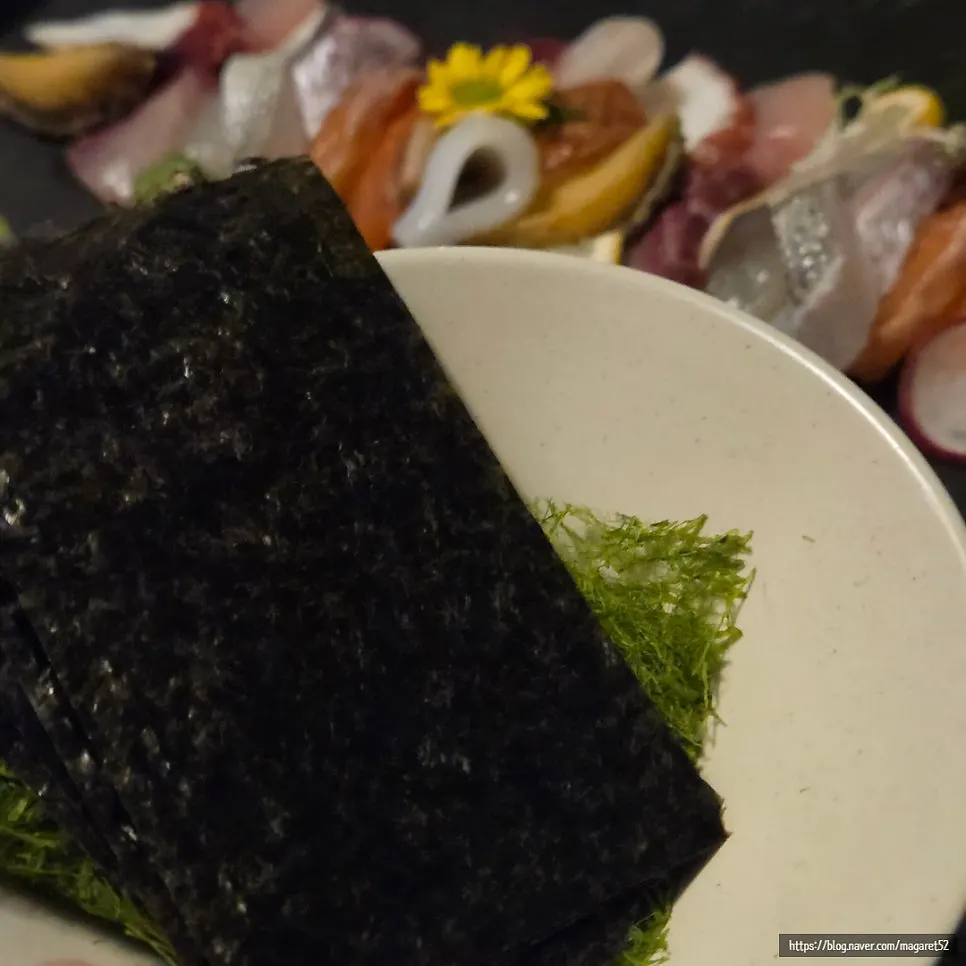 Sashimi with wasabi on top, alongside seaweed