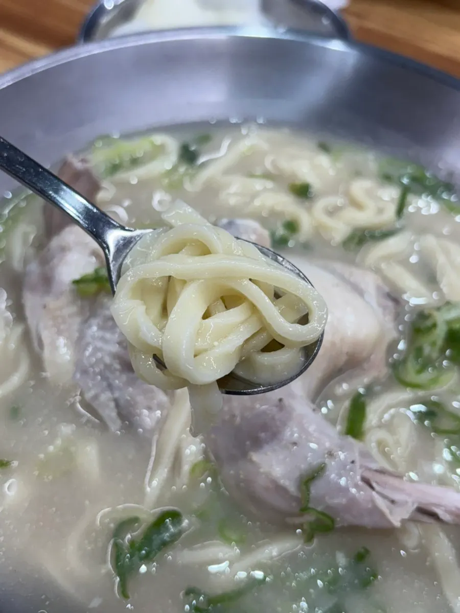 Chicken bone broth kalguksu topped with perilla powder