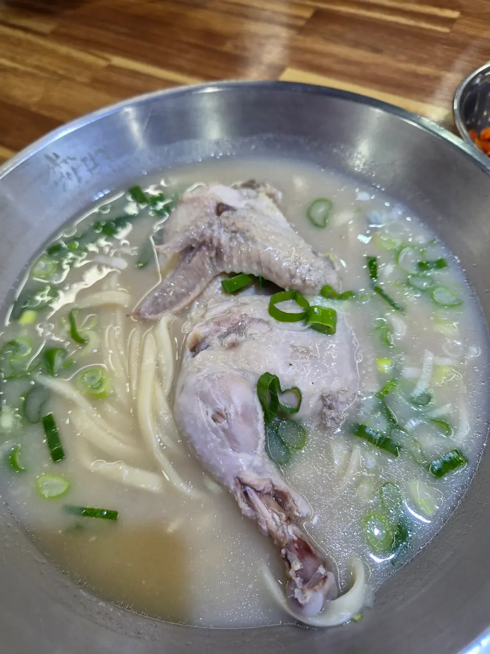 Dak kalguksu with perilla seeds on top of the chicken bone broth