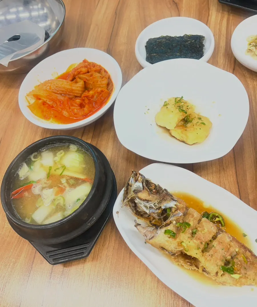 Basic side dish spread including kimchi pancake and grilled fish