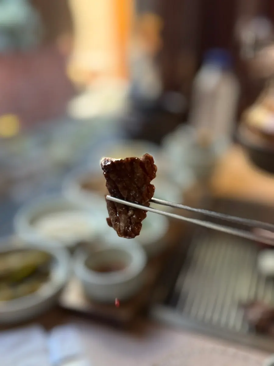A piece of hanwoo raw short rib dipped in the egg yolk sauce