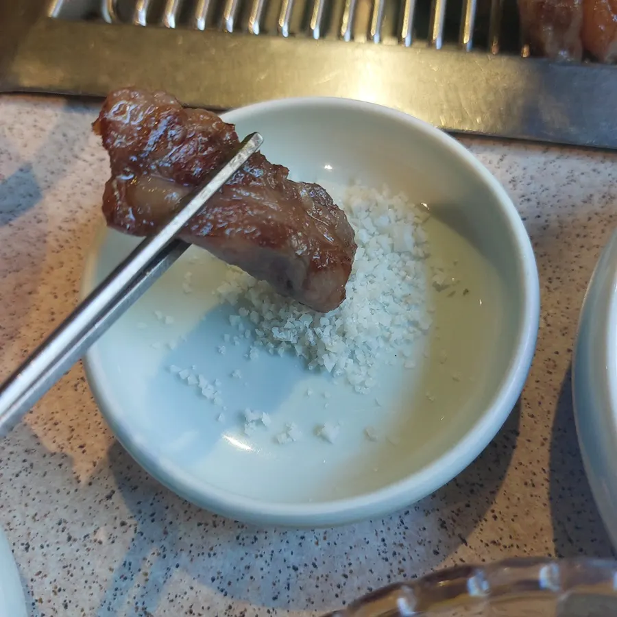 A piece of hanwoo dipped in soft-boiled egg sauce