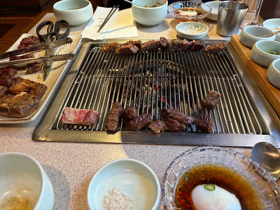 Charcoal-grilled glazed short ribs being cooked tableside