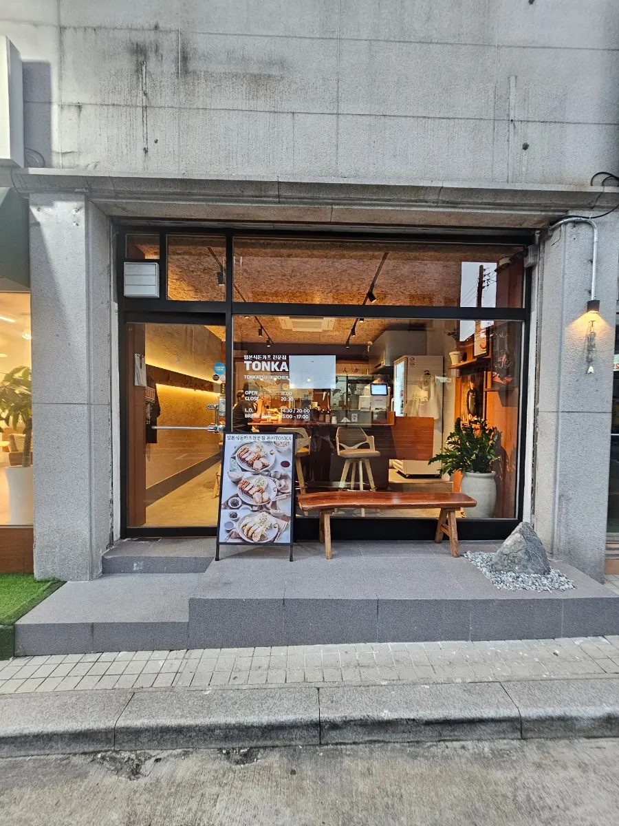 통유리에 TONKA 레터링이 붙은 톤카 외관과 원목 벤치