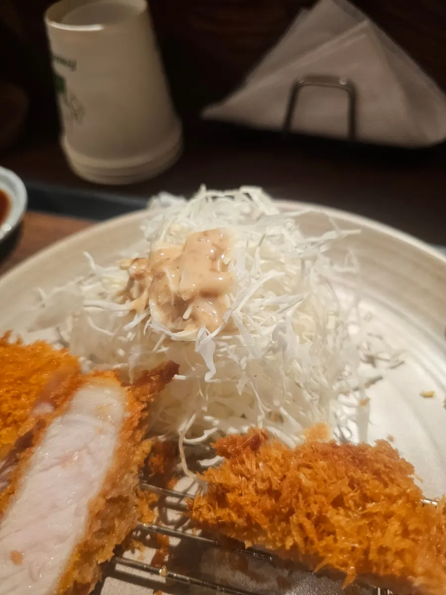 땅콩소스를 뿌린 양배추 샐러드와 돈카츠