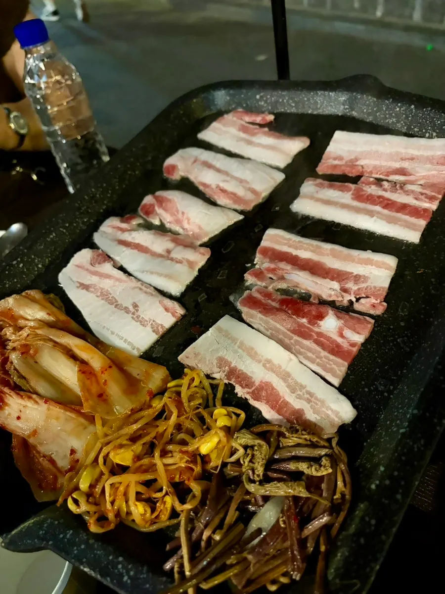 Thin frozen pork belly cooking with kimchi