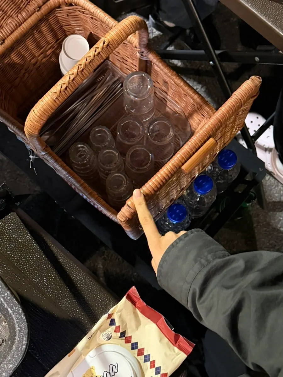 Shot glasses, utensils, and tissues inside the picnic bag