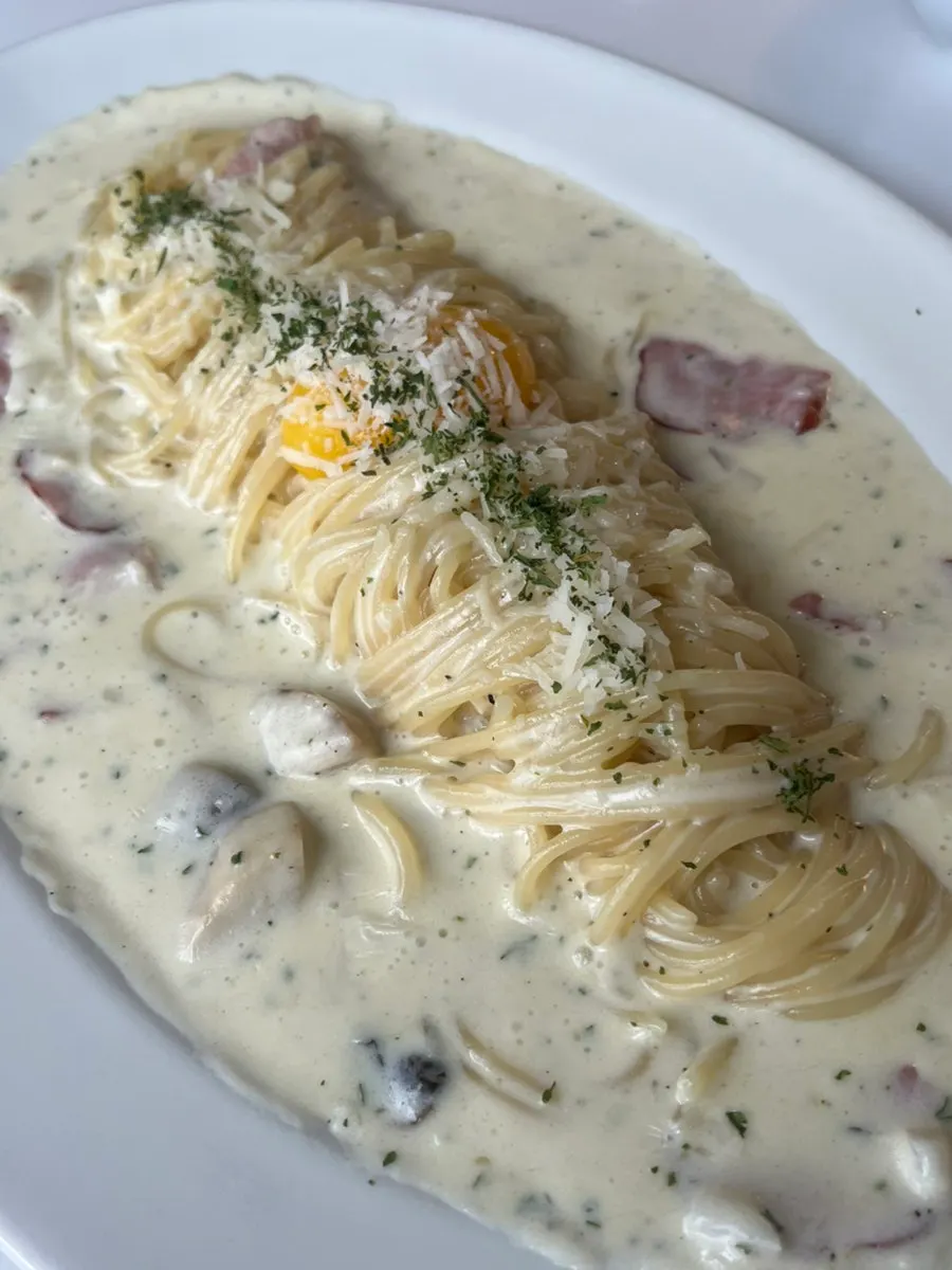 Cream carbonara topped with an egg yolk