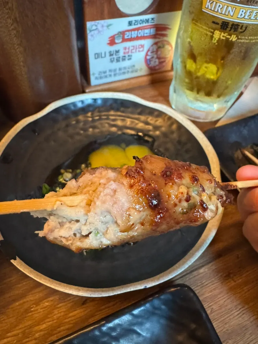 쯔쿠네 완자를 노른자에 찍는 모습