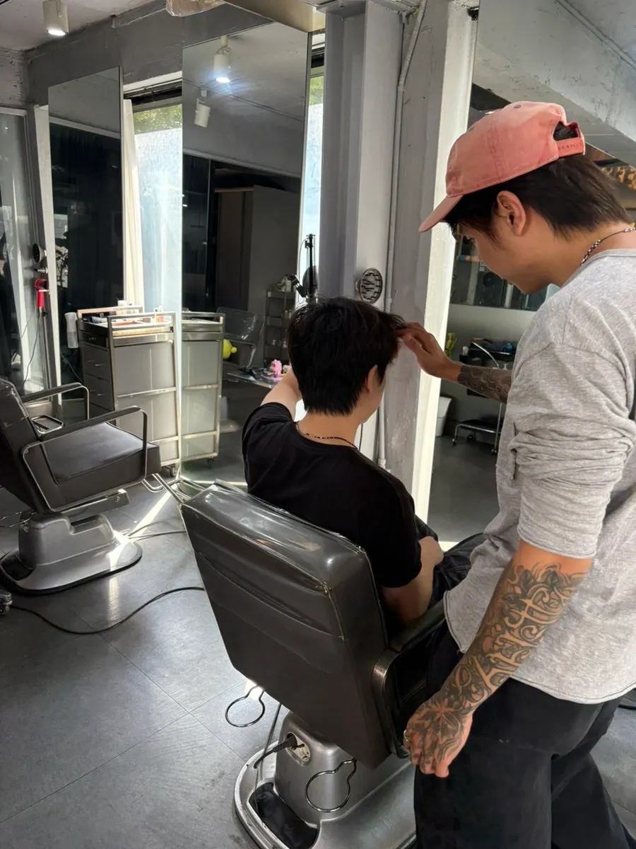 Consultation scene checking head shape and hair condition before the service