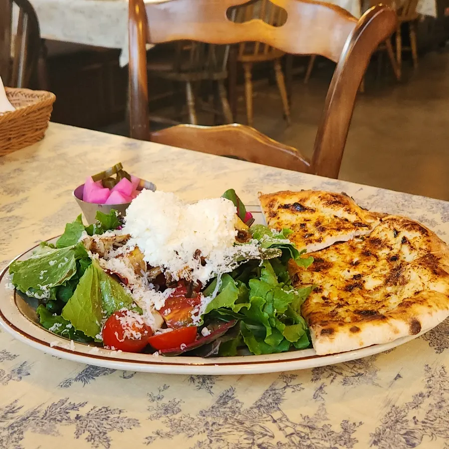Table spread of gnocchi, sandwich and salad shared by three
