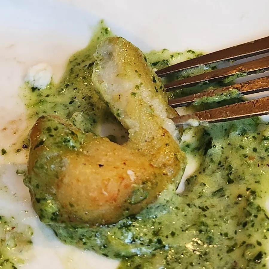 Basil cream gnocchi lifted on a fork