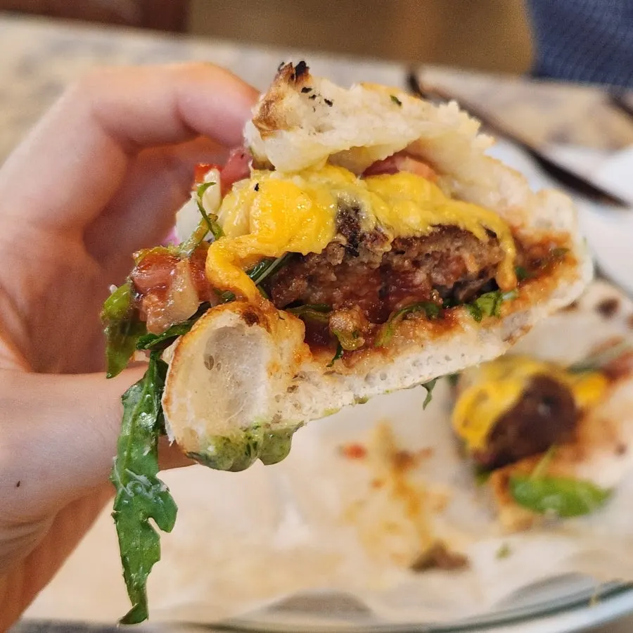 Wood-fired sandwich showing arugula and cheese