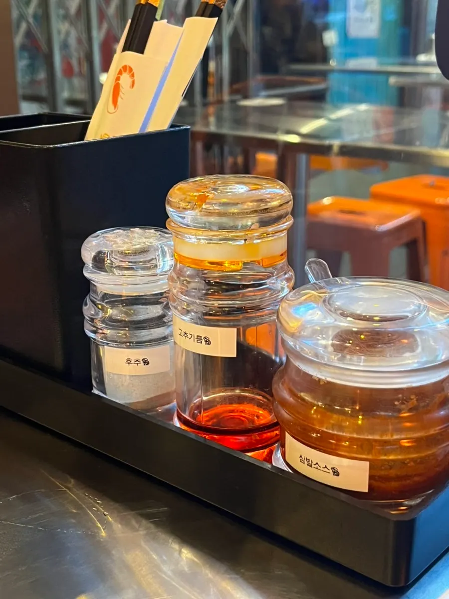 Pepper, chili oil, and sambal sauce set on the table