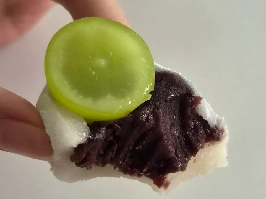 Close-up of a single chapssaltteok topped with fruit