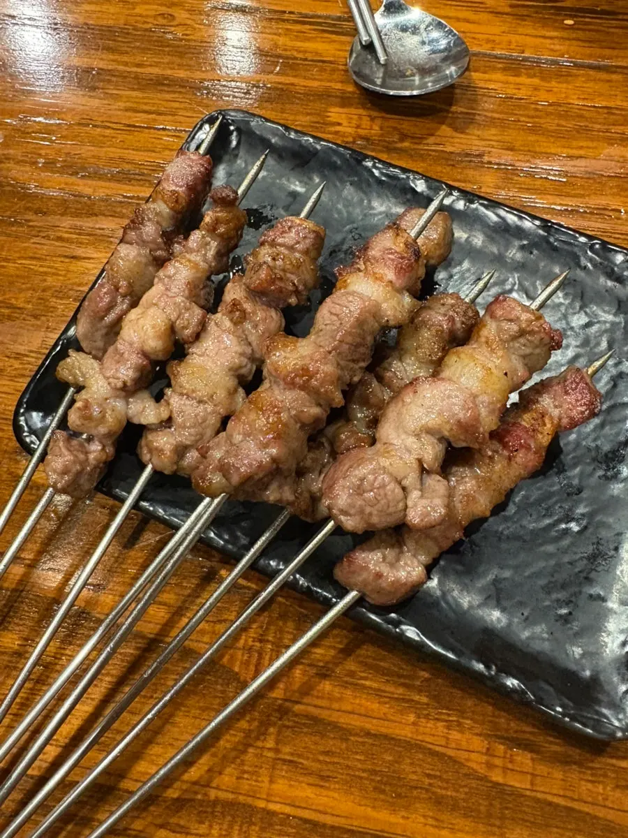 Large lamb skewers turned and grilled by hand