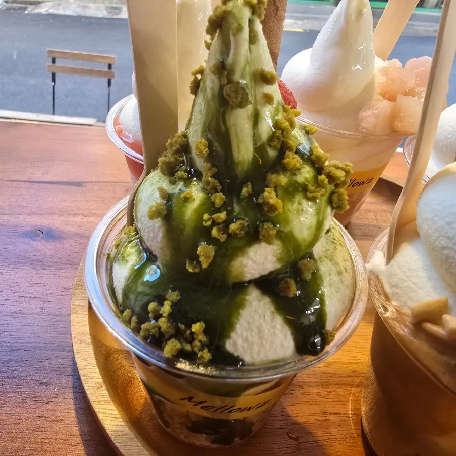 Soft serve topped with matcha syrup and crumble