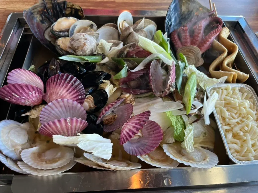 A full spread of steamed clam soup at Bada Super in Geobukseom