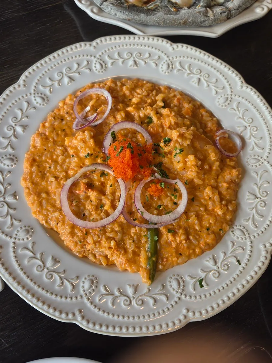 A slice of wood-fired shrimp pizza with honey drizzle