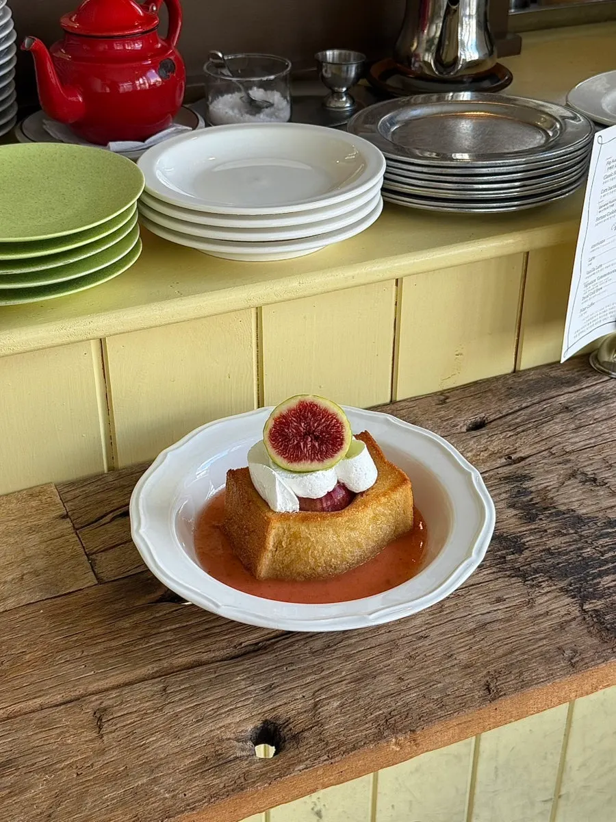 Bite-sized piece of fig toast dipped in sauce