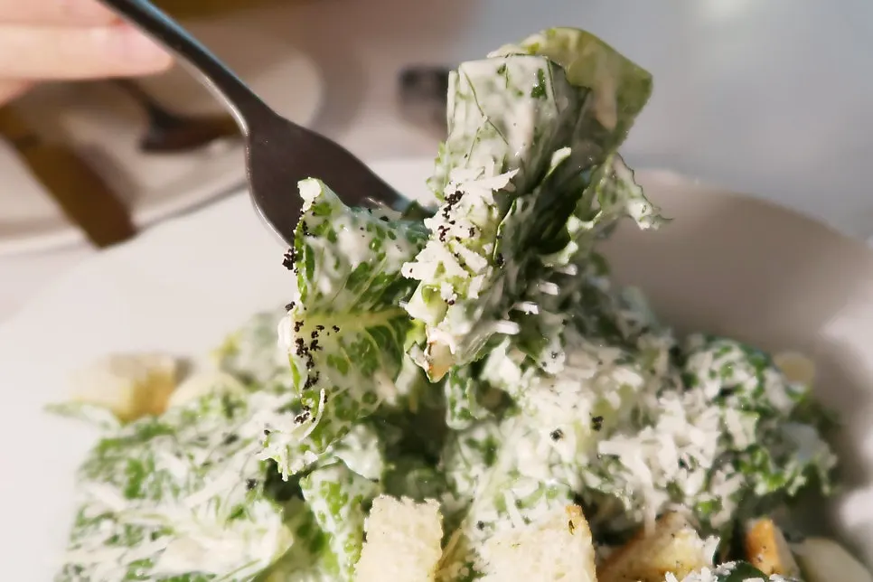 Caesar salad topped with cheese and crunchy toasted bread