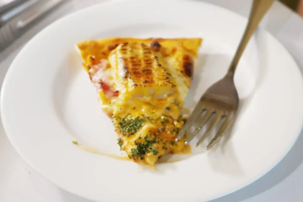 A slice of corn pizza served on a plate