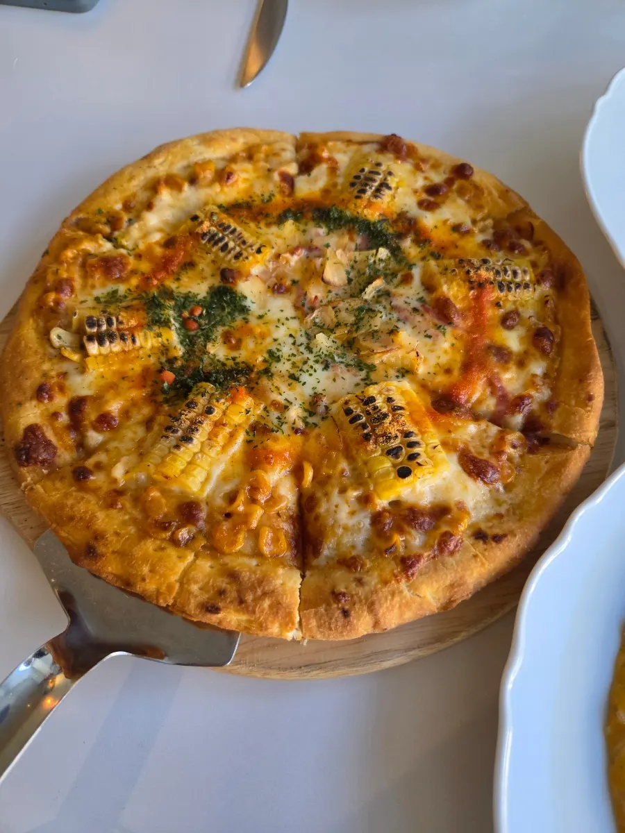 Corn pizza piled high with corn kernels