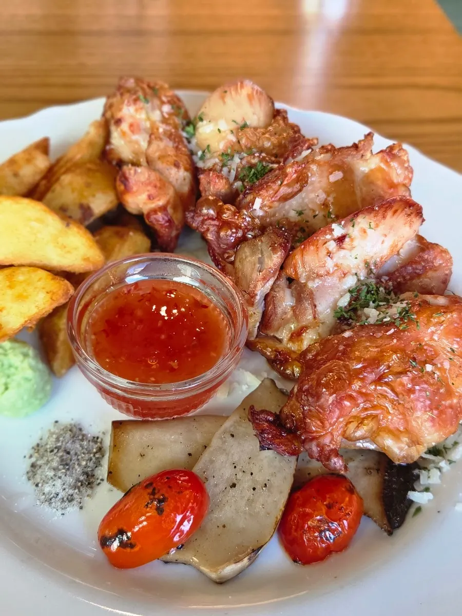 Chicken steak served with wedge fries and roasted vegetables