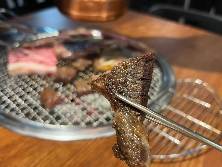 Staff member grilling the fresh ribs over charcoal