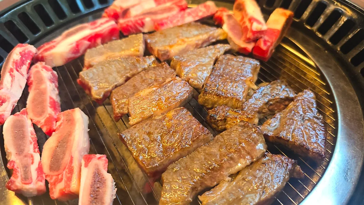 Staff member grilling beef ribs and bones