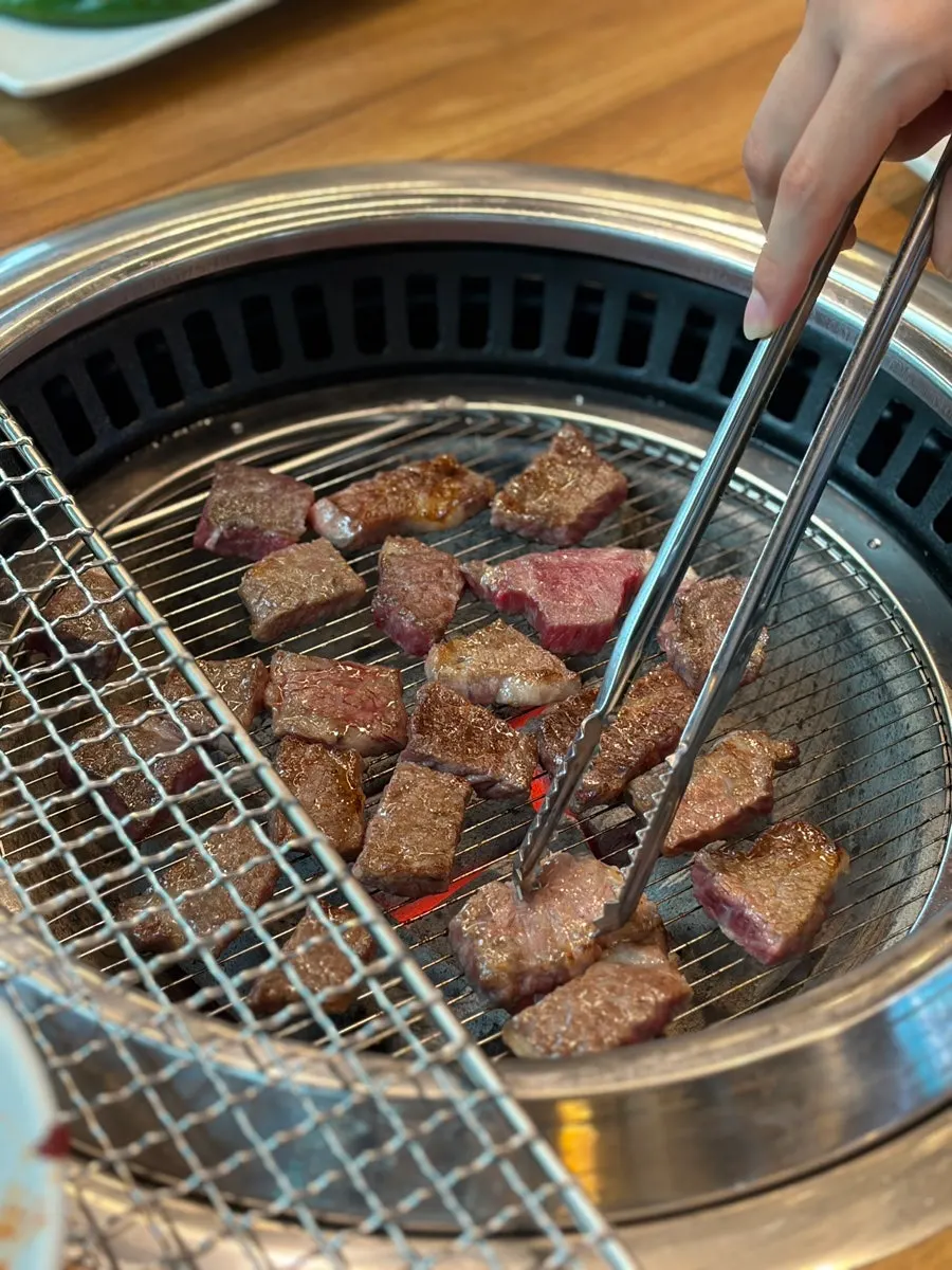Raw short ribs grilling over charcoal