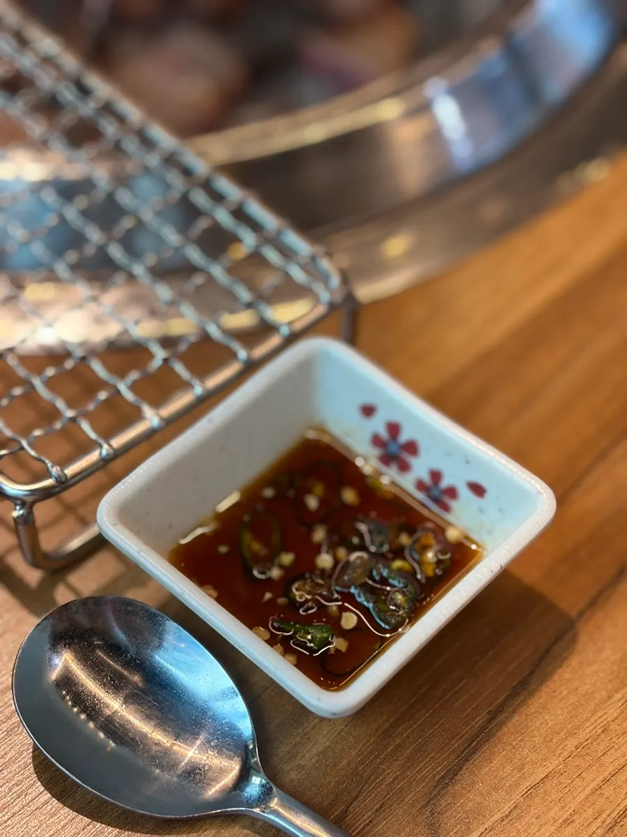Sliced pieces of raw short rib being grilled