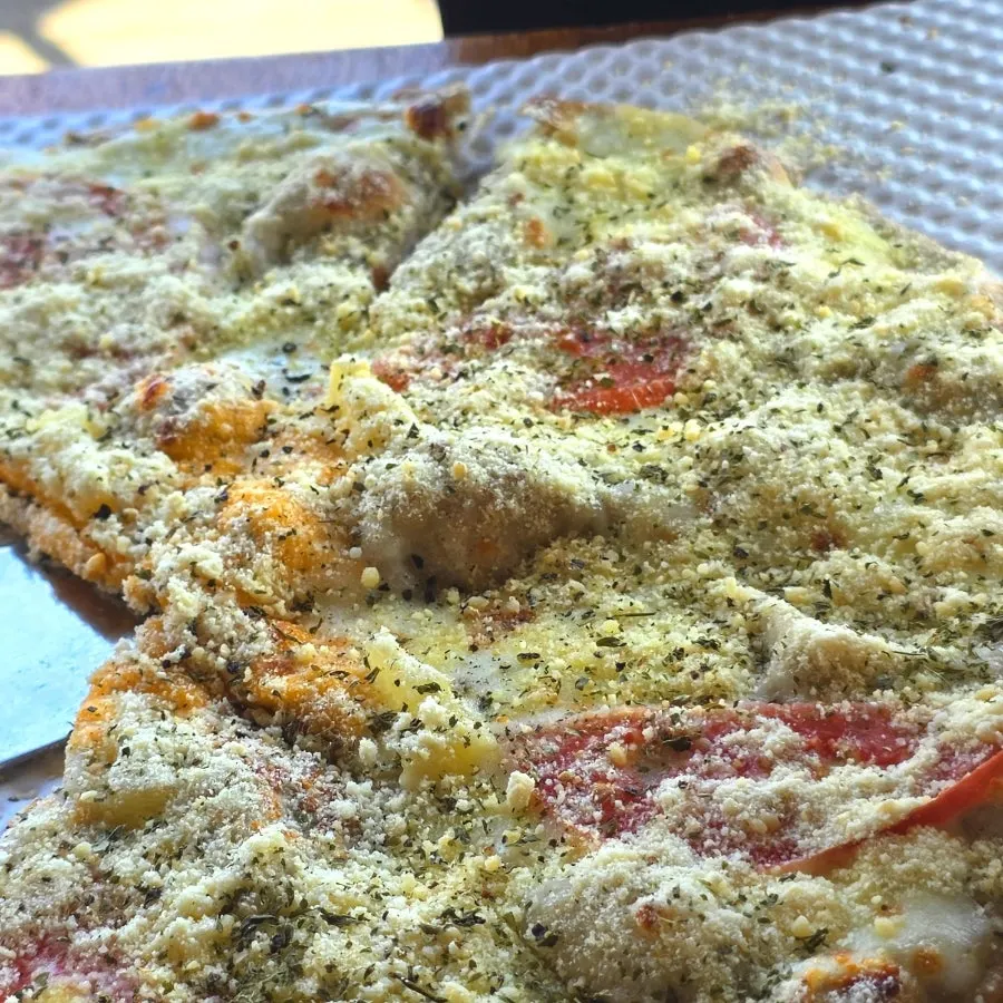 A slice of soseom pizza dipped in garlic sauce