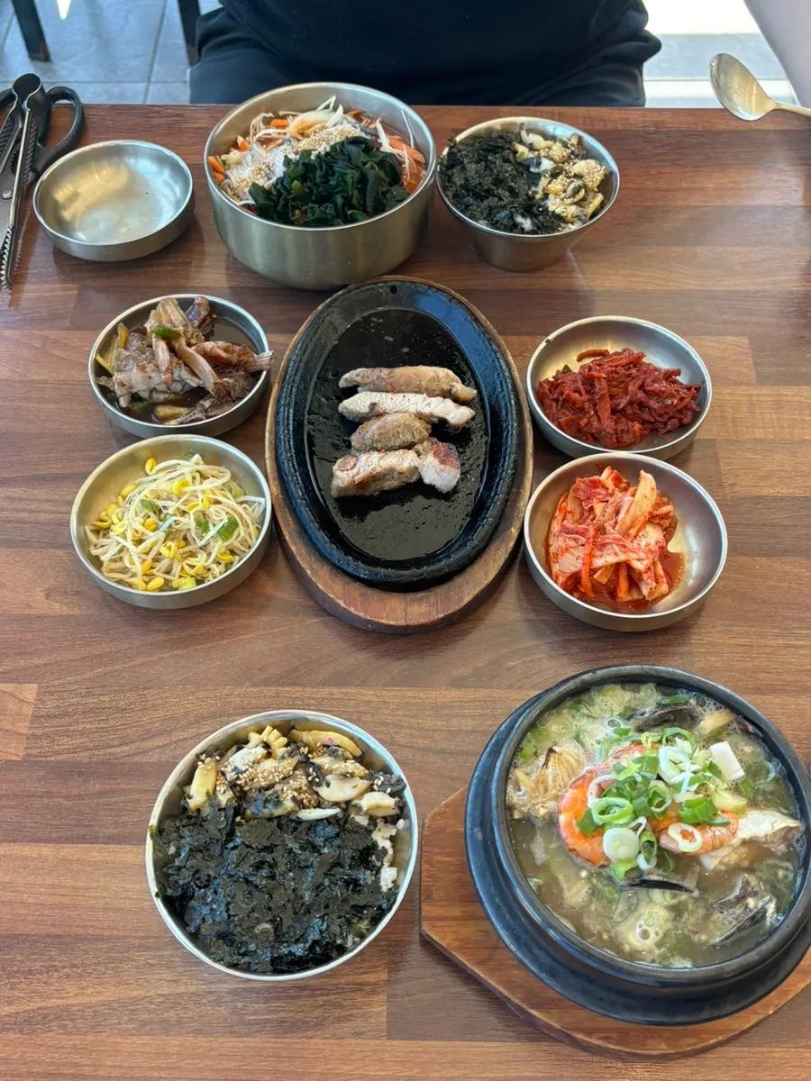 A full abalone meal with rice and side dishes laid out