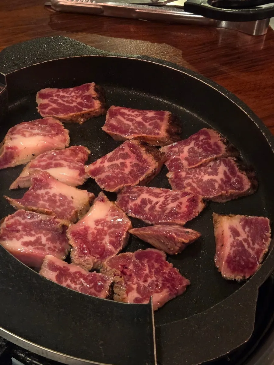 Woodae galbi grilling over charcoal