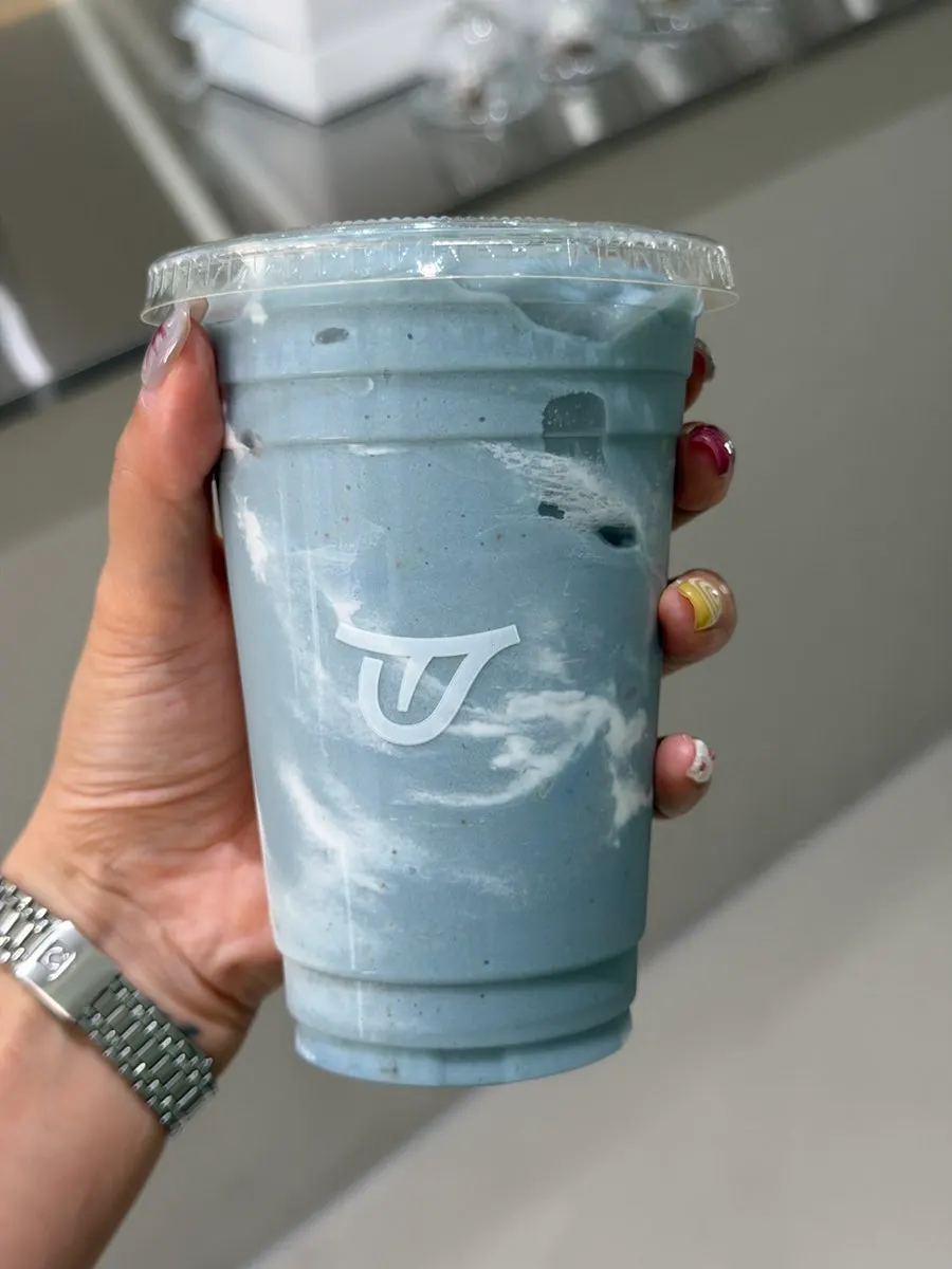 Blue Stress Down smoothie held in hand with white logo