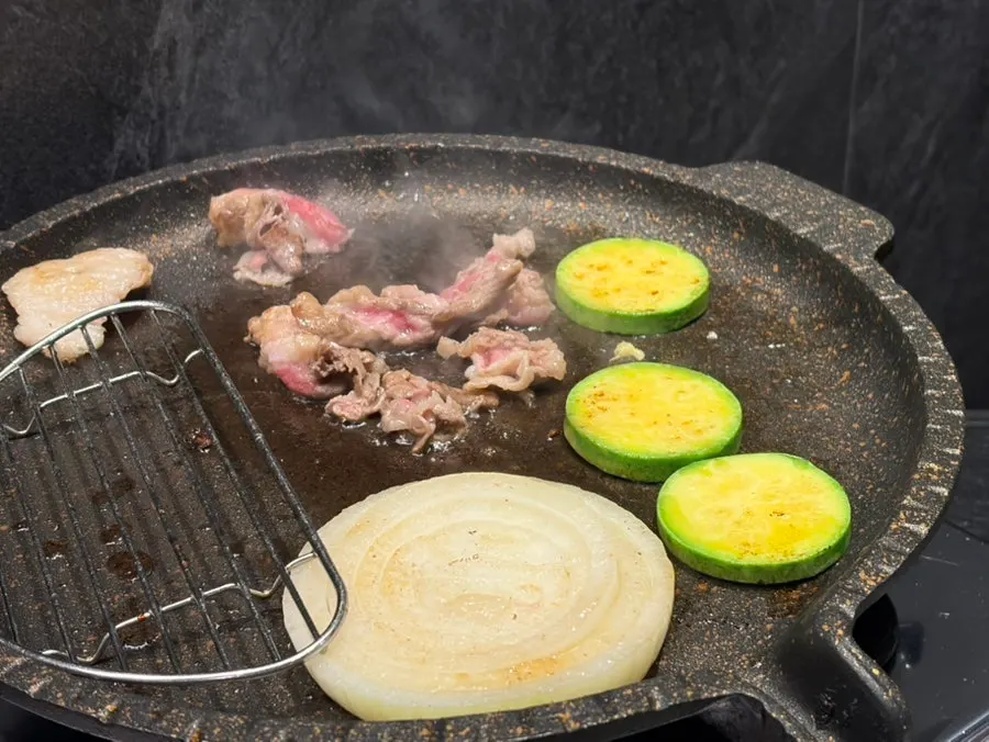 Beef brisket grilling together with vegetables