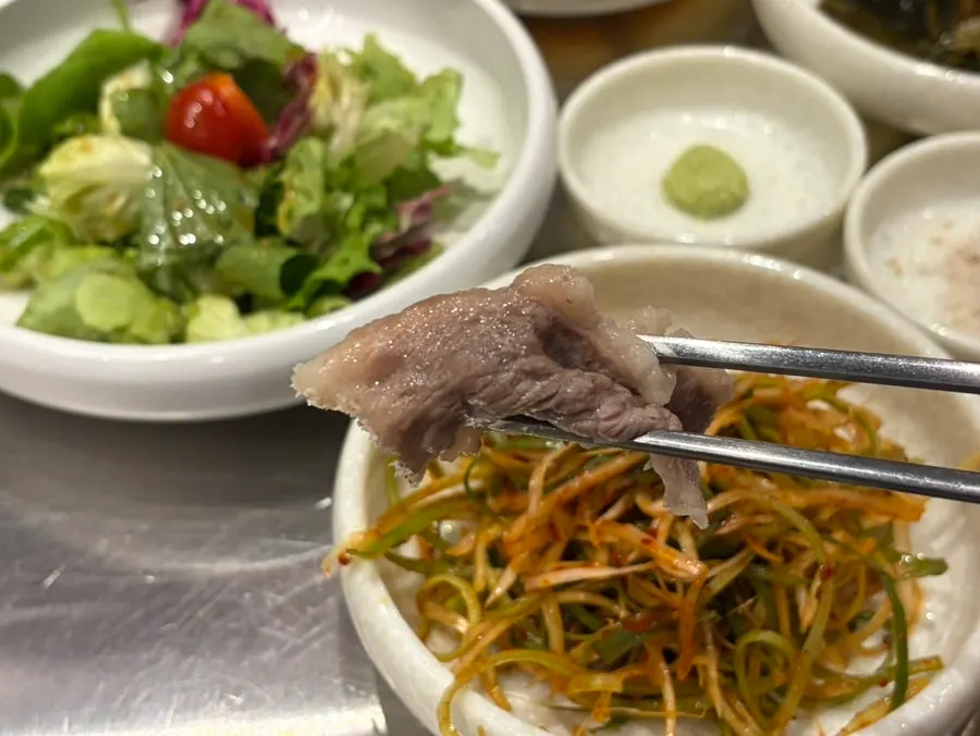A piece of beef brisket with scallion shreds and wasabi