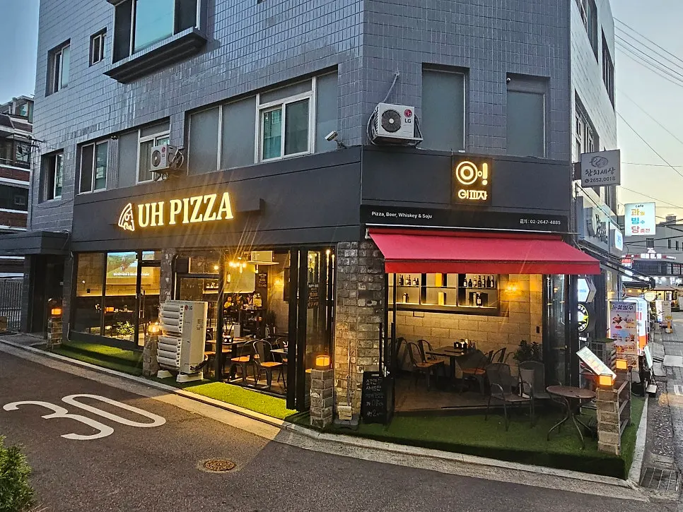 UH PIZZA 간판이 켜진 어피자 외관