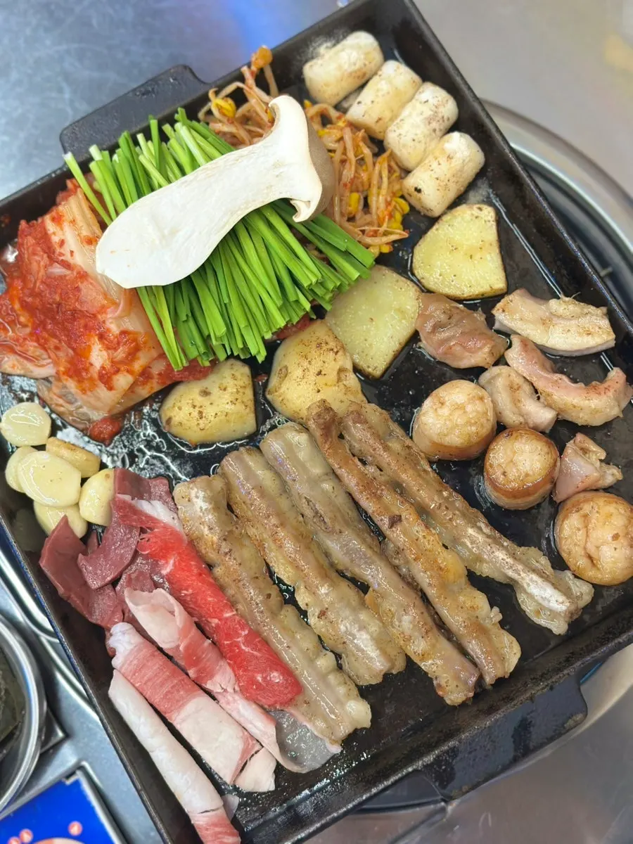 Table spread of raw liver, tripe, tteokbokki and seaweed soup banchan