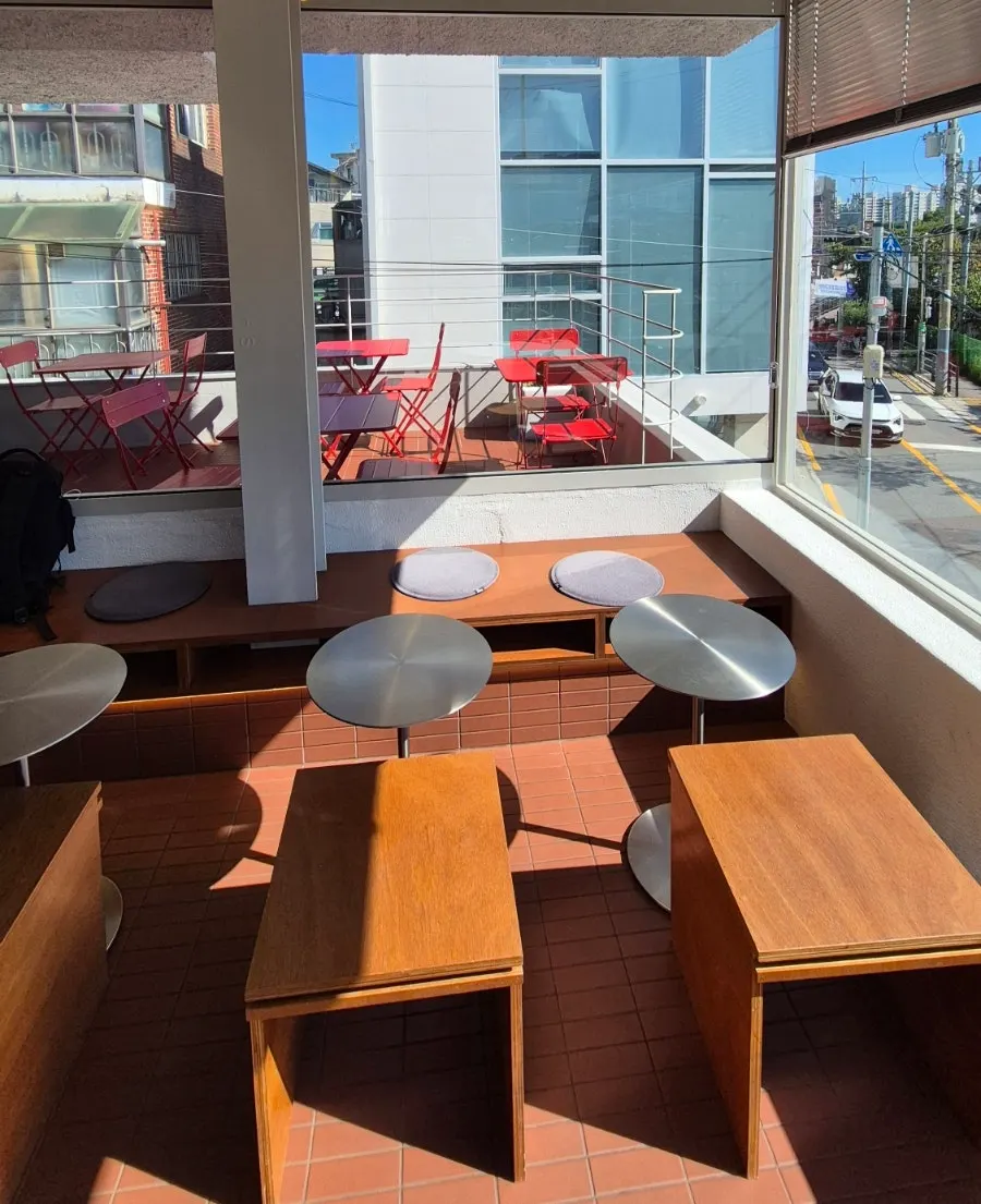 Second-floor seating with wood benches and a window view