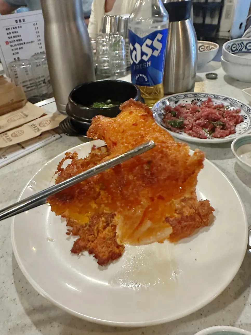 A crispy-edged piece of minari kimchi pancake