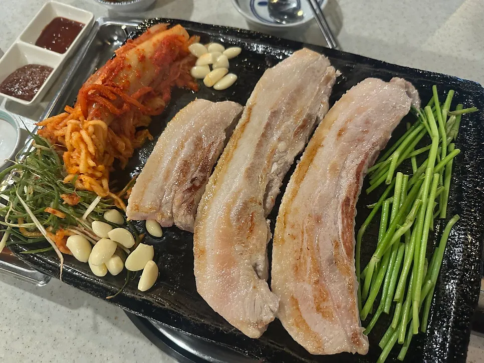 Pork belly and minari turning golden brown on the grill