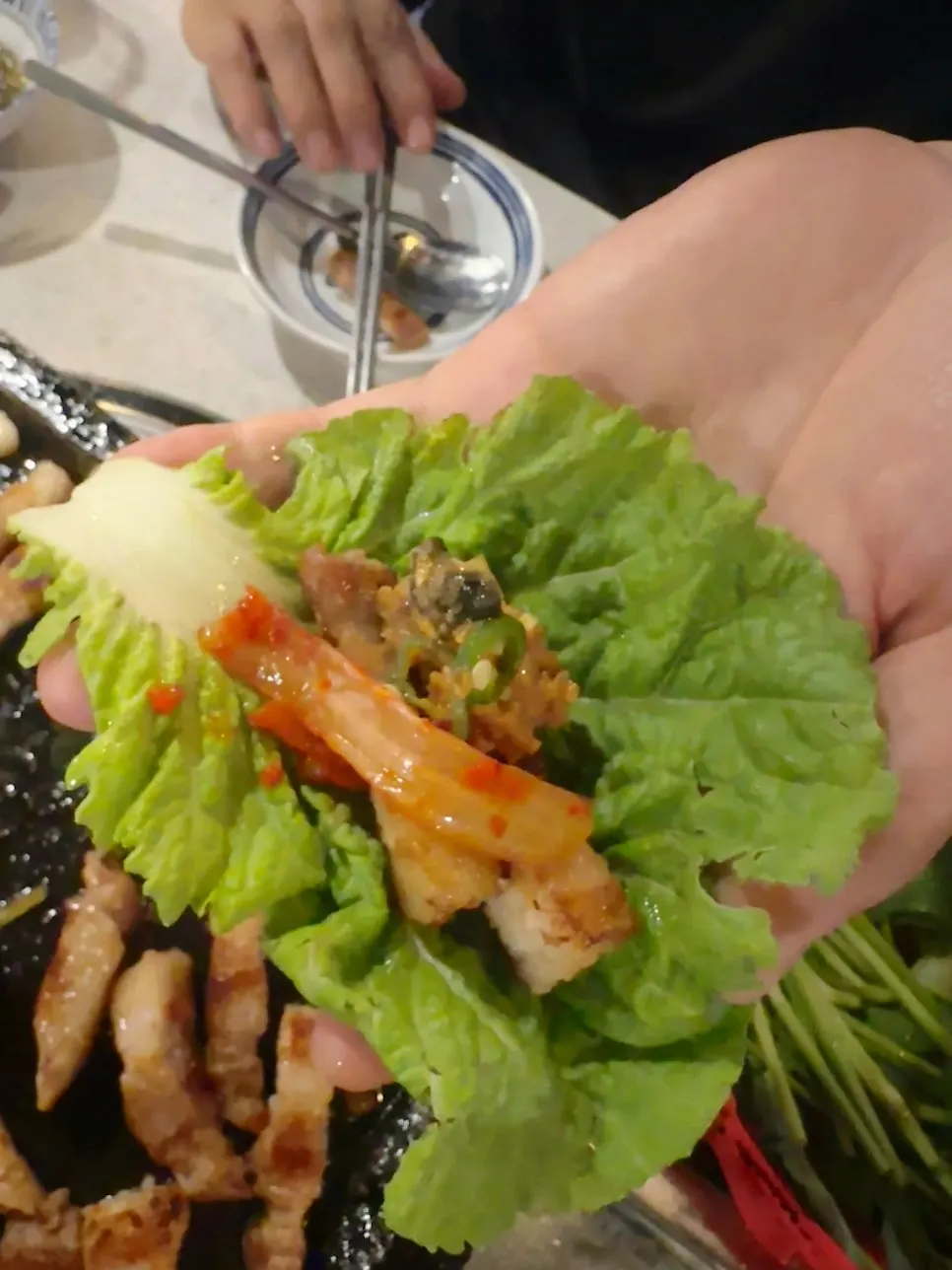 Pork belly wrapped in lettuce leaves