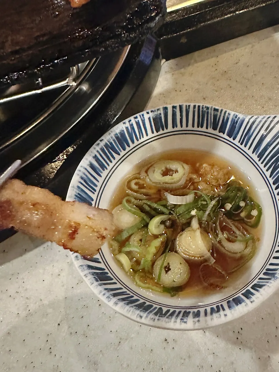 A piece of pork belly dipped in individual sauce