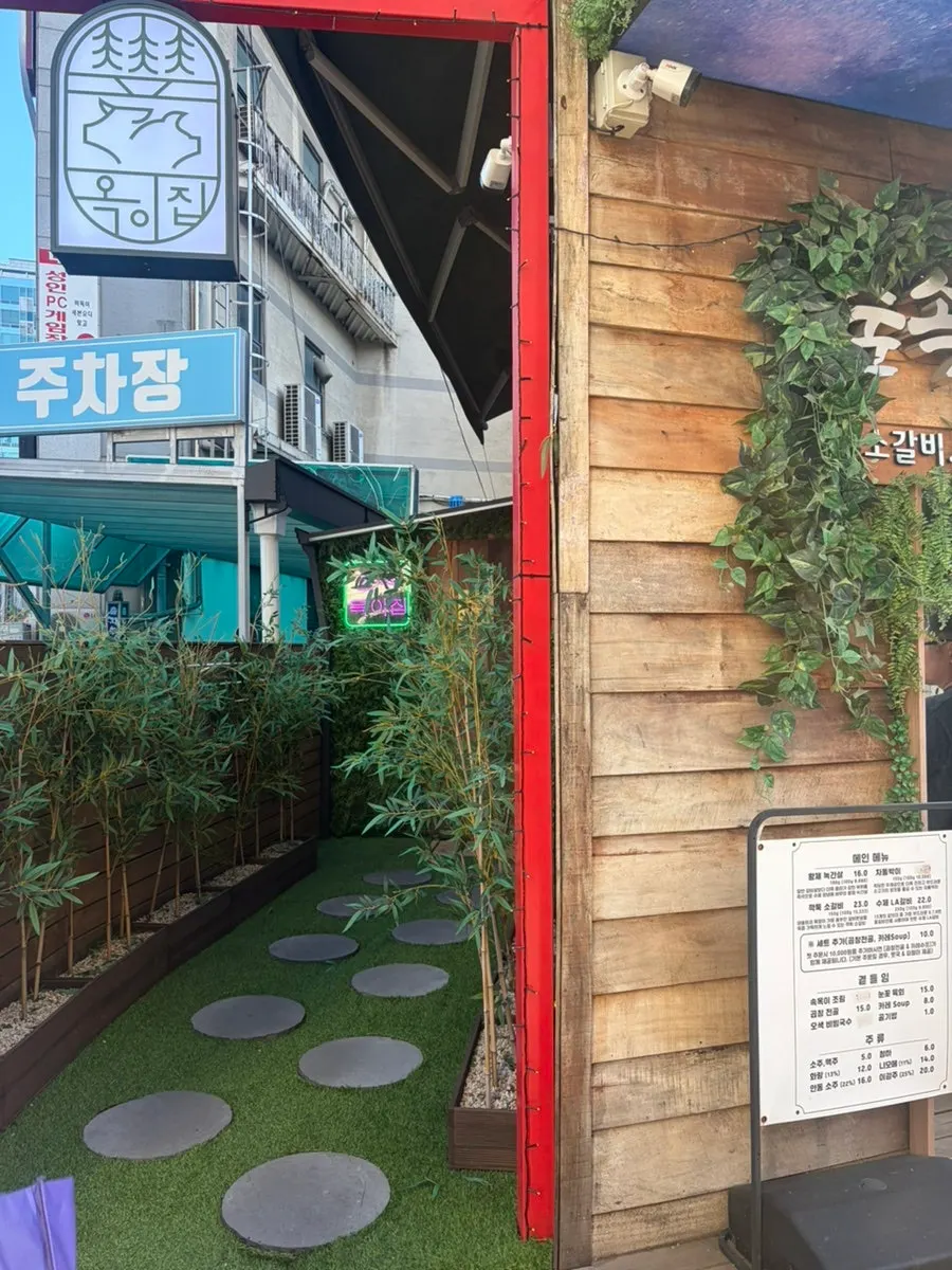 Fasad restoran daging dengan tumbuhan dan dinding kayu