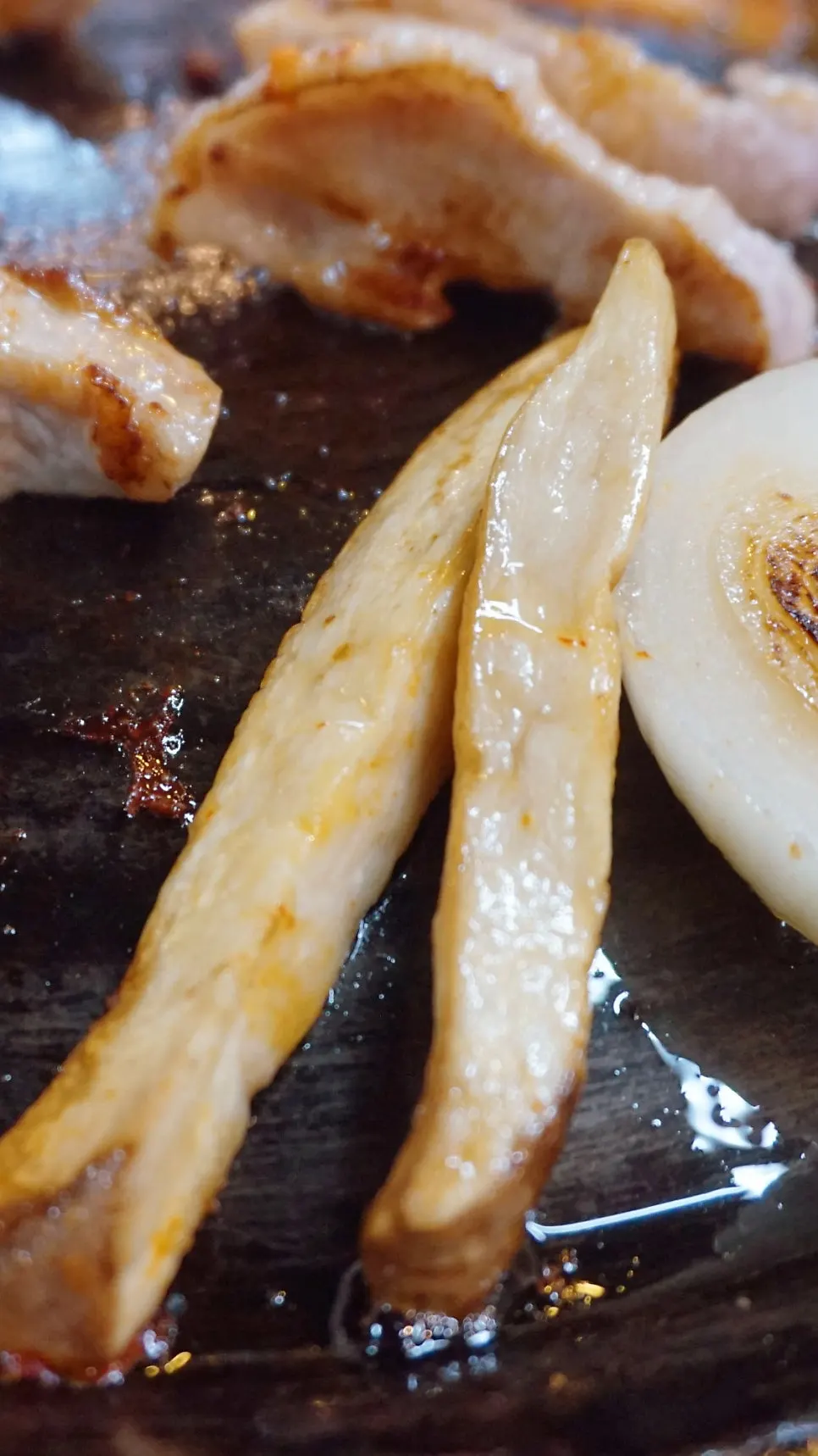 솥뚜껑 위 삼겹살과 아래쪽 김치, 버섯 구이