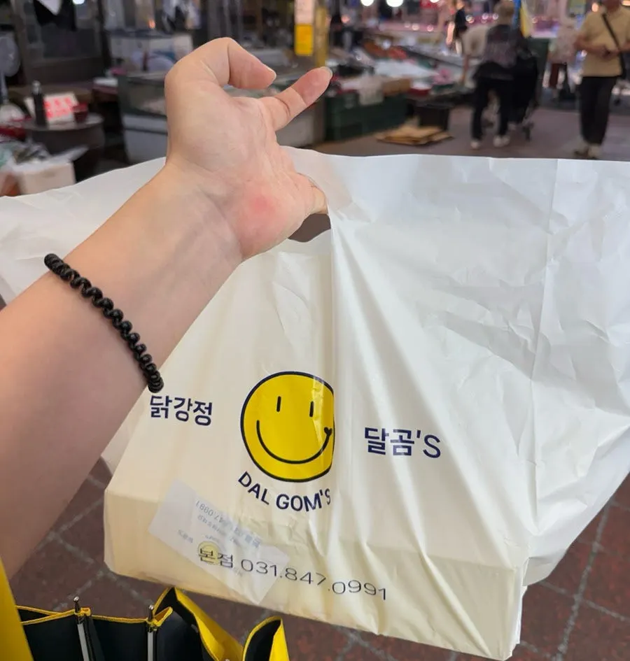 Dakgangjeong being tossed with sauce for takeout
