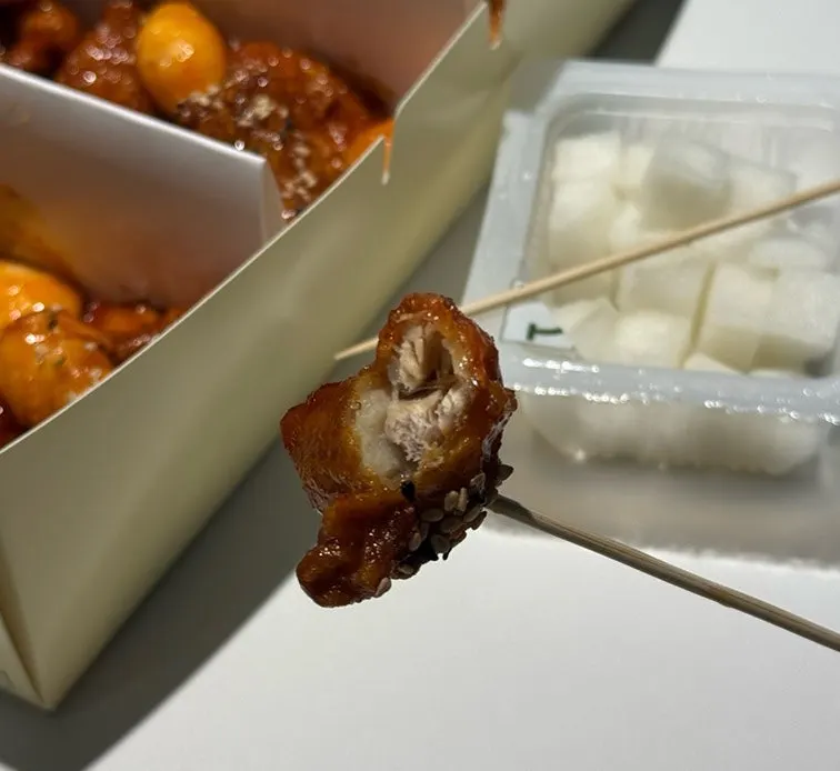 A bite of dakgangjeong enjoyed with beer