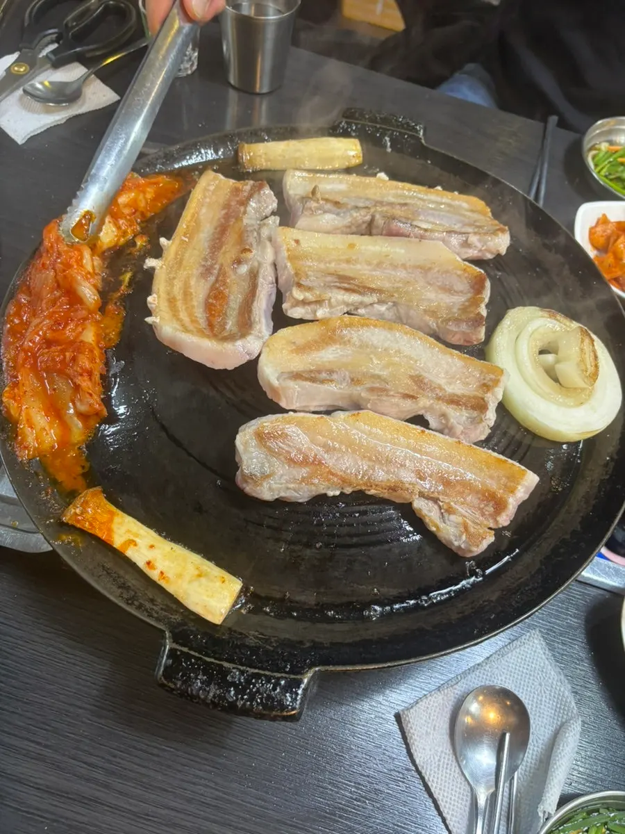 Pork belly placed on the cauldron-lid grill